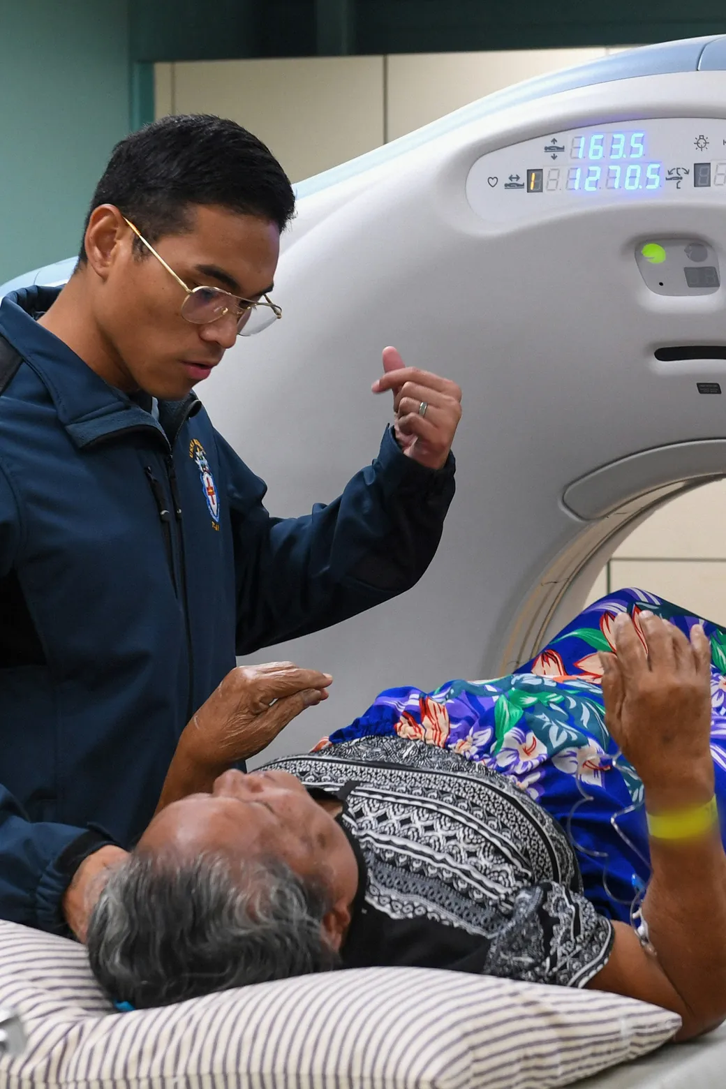 Clinician coaching a patient through breath-hold instructions during a cardiac acquisition